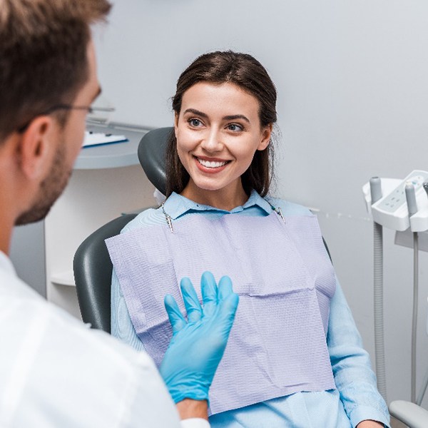 Young woman smiling at dentist during dental checkup