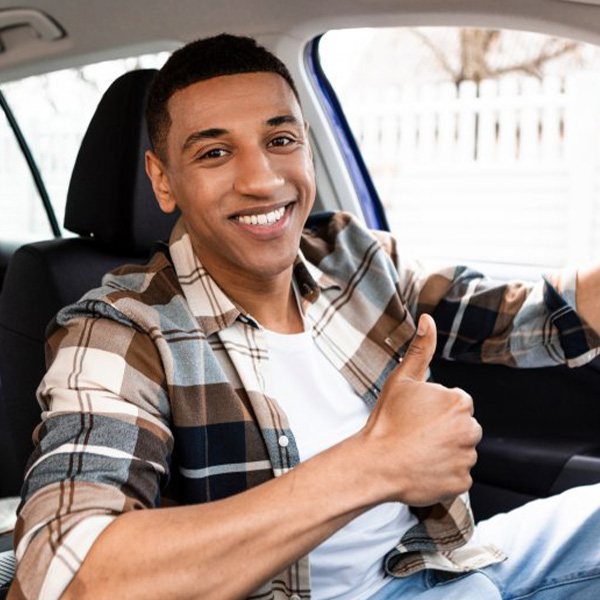 Man smiles in car