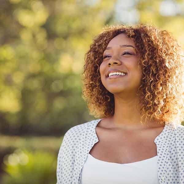 Woman in white shirt outside smiling